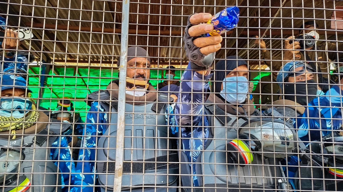 A security official offers food to protesting farmers in Patiala (photo: PTI)