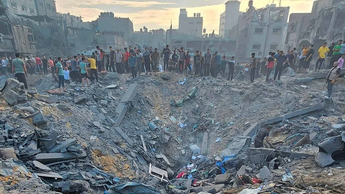 Survivors look down on a cratered residential area in Gaza