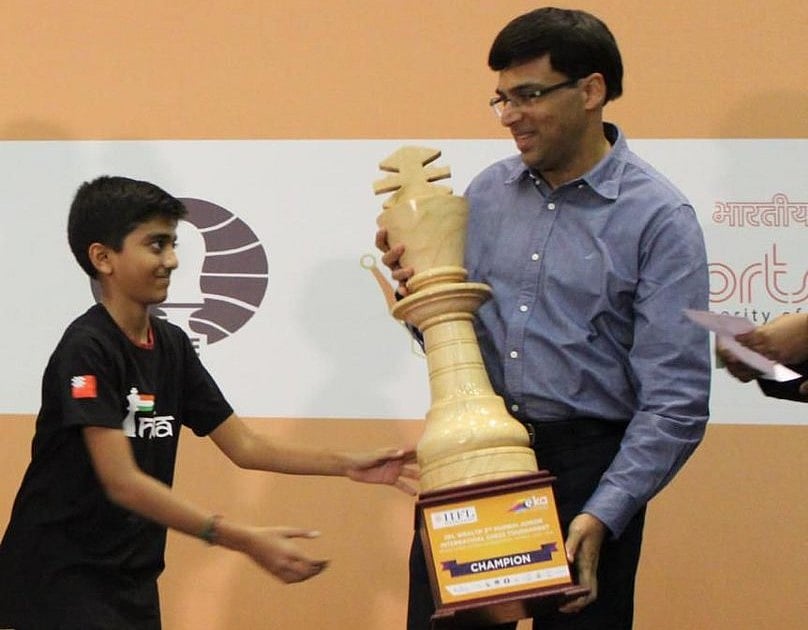 Anand hands over a age group trophy to D. Gukesh (photo: @Viswanathan Anand/X)