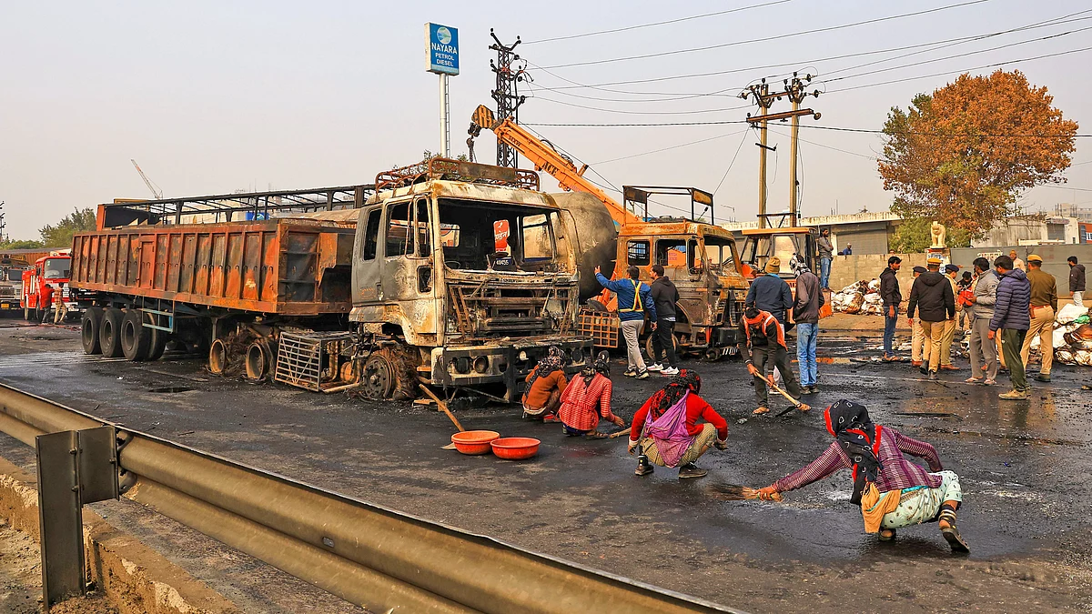 Workers clean the accident site in Jaipur on 20 December (photo: PTI)