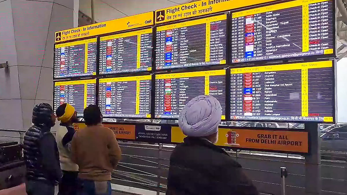 File photograph of passengers looking at the display board at Delhi Airport (photo: PTI)