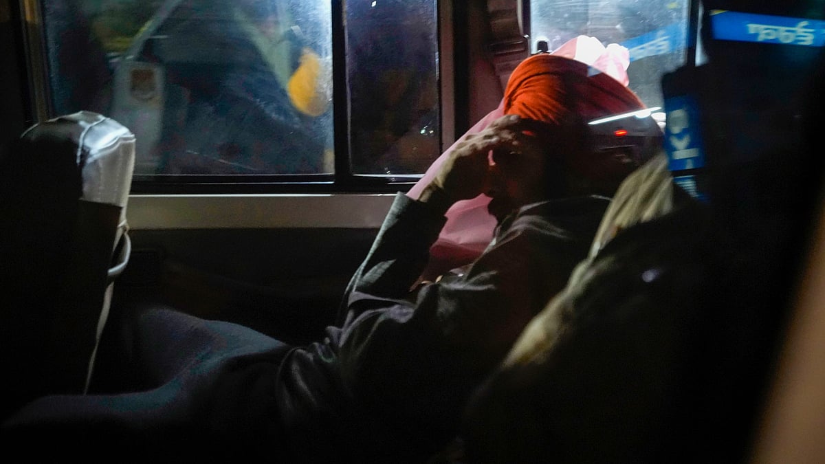 A Sikh deportee being escorted away from Amritsar airport in a police vehicle