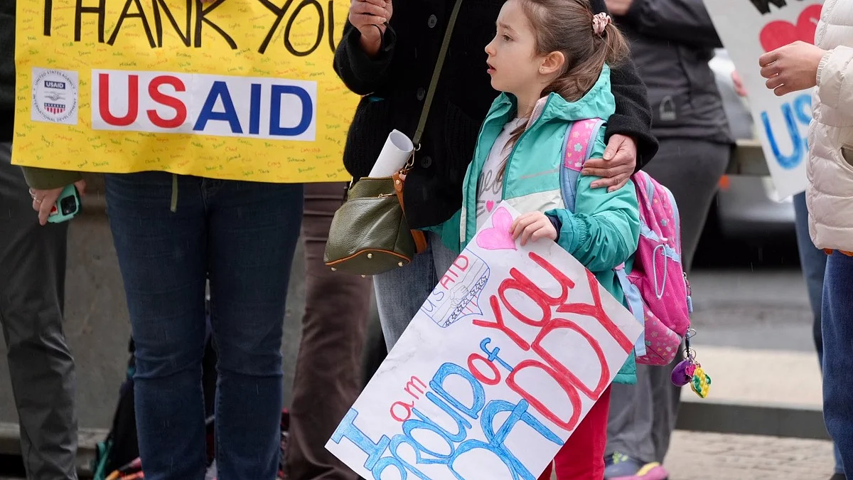The child of an USAID worker at a 'thank you' demonstration for former or furloughed staffers