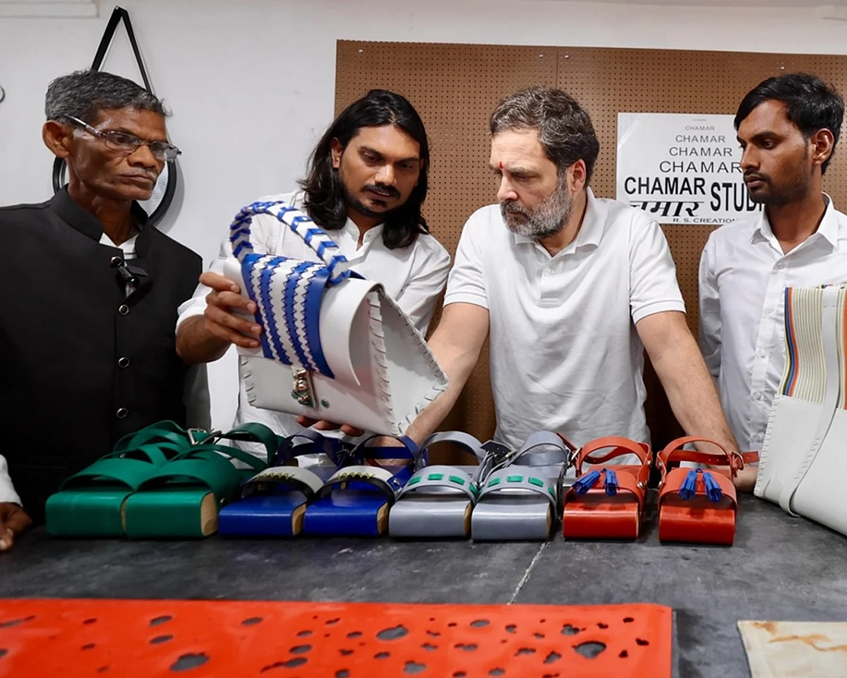 Rahul Gandhi with Sudheer Rajbhar (L) of Chamar Studio in Dharavi, with footwear artisan 'Ramchet mochi' (far left) of Sultanpur, whose son he promised to see educated further in the craft
