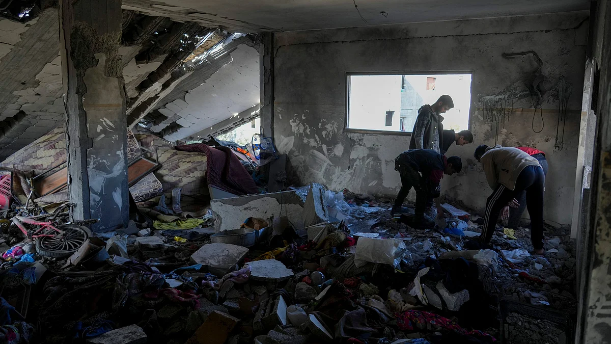 Palestinians inspect a damaged building in central Gaza Strip on 18 March (photo: AP/PTI)
