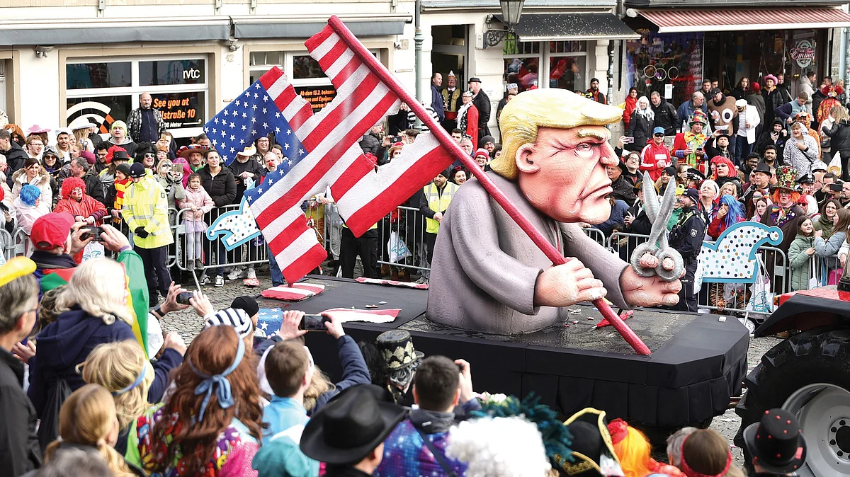 An effigy of Donald Trump holding a cut-up US flag in the shape of a swastika