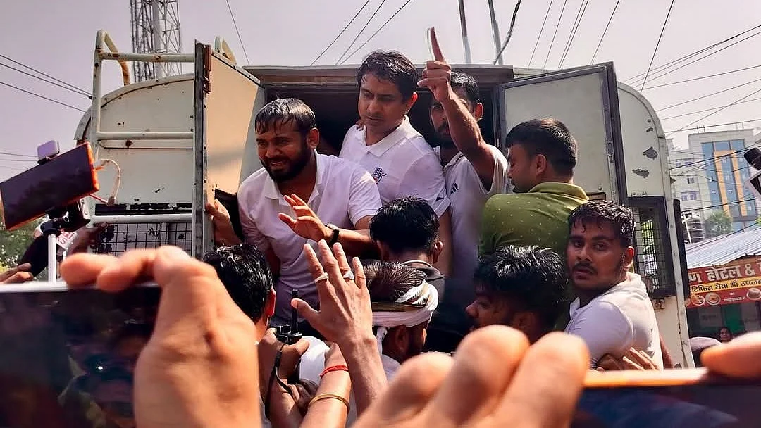 Kanhaiya Kumar, being taken into a police van, gestures for calm