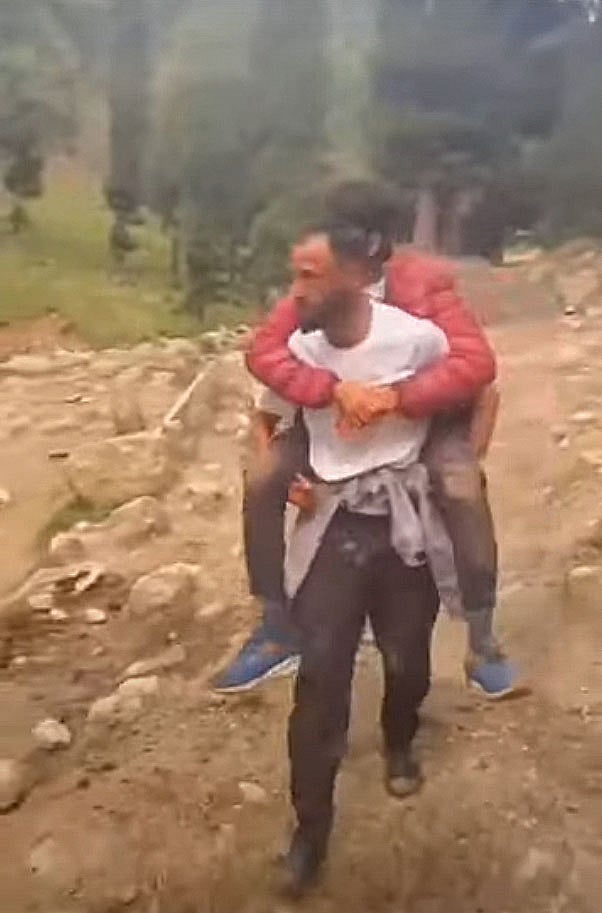A local guide carrying an injured tourist