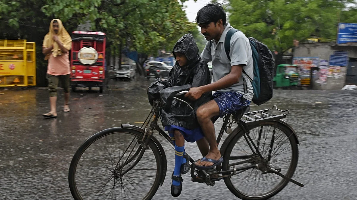 A child goes to school during heavy rainfall in Delhi on 2 May (photo: Vipin/NH)