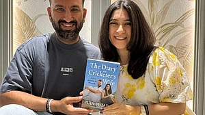 The Pujaras pose with the book (photo: @cheteshwar1/X)