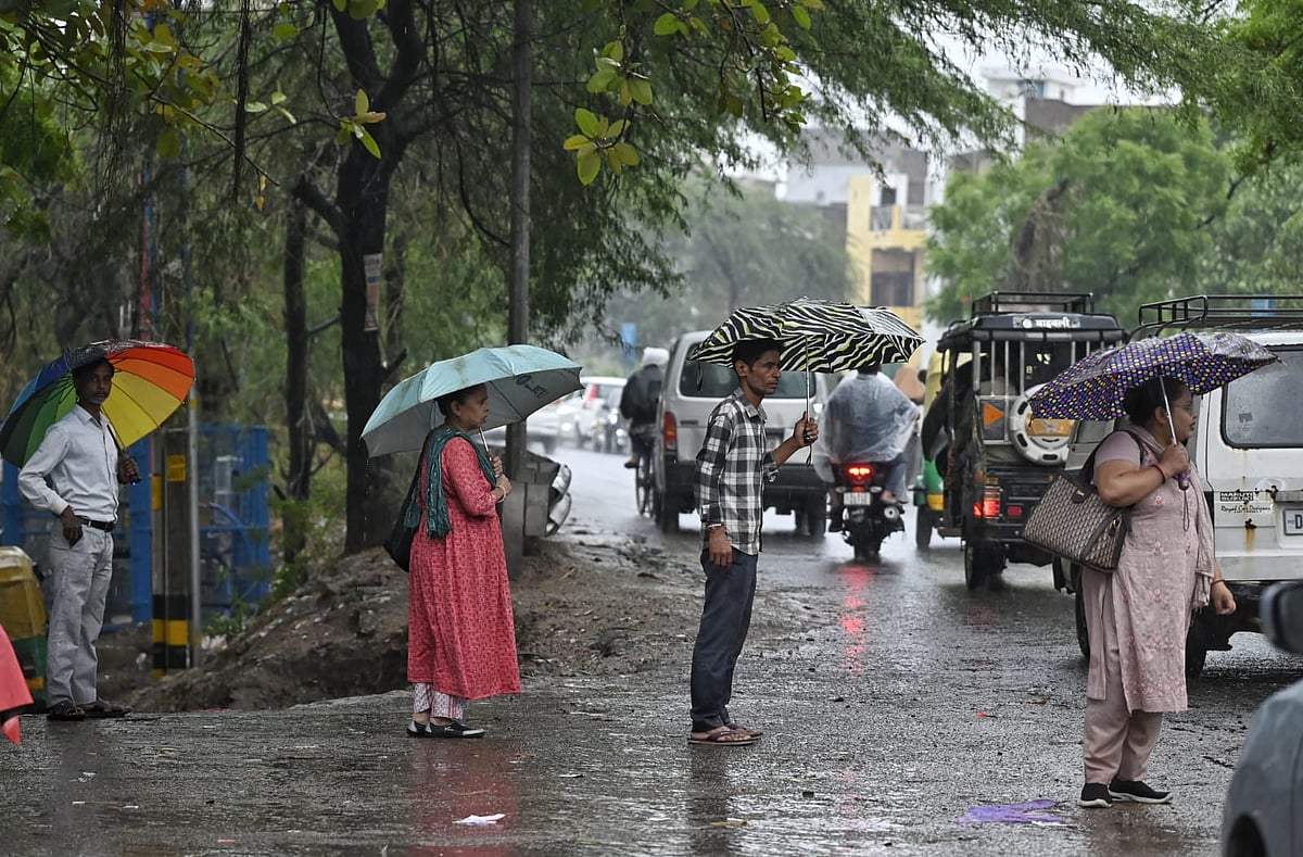 Residents use umbrellas as rains batter the national capital. (photo: Vipin/NH)