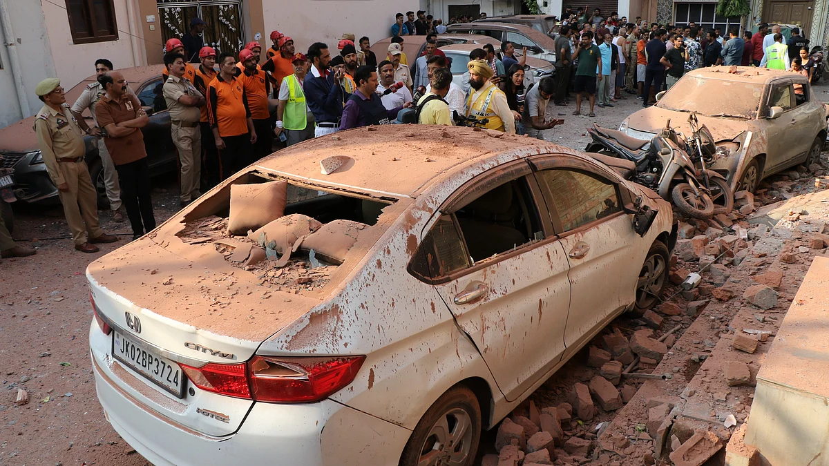 Civilians gather near vehicles damaged in Pakistani attack in Jammu on 10 May (photo: PTI)