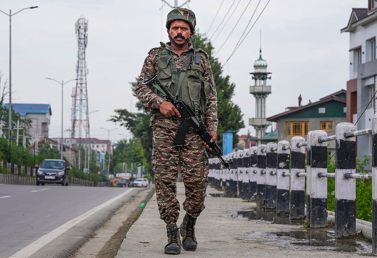 A security official stands guard on a road leading to Srinagar airport (photo: PTI)