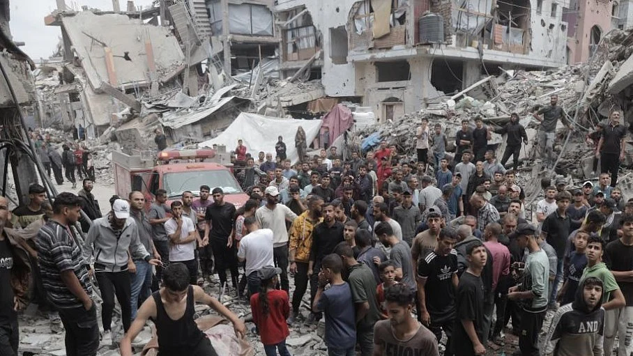 Residents gather near the destroyed buildings in Gaza (photo: IANS)