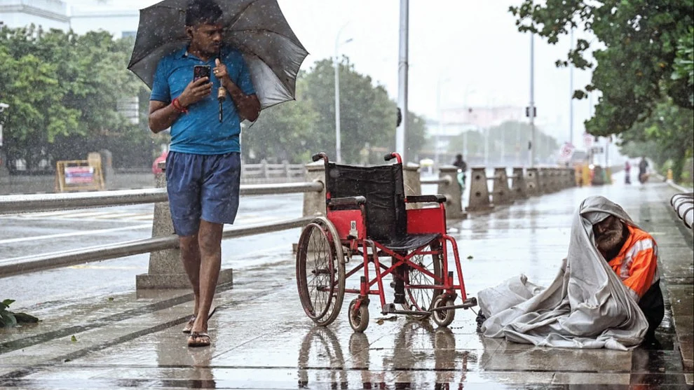 A physically challenged man tries to shelter himself during cyclone Fengal, Chennai, Nov. 2024 (Getty)
