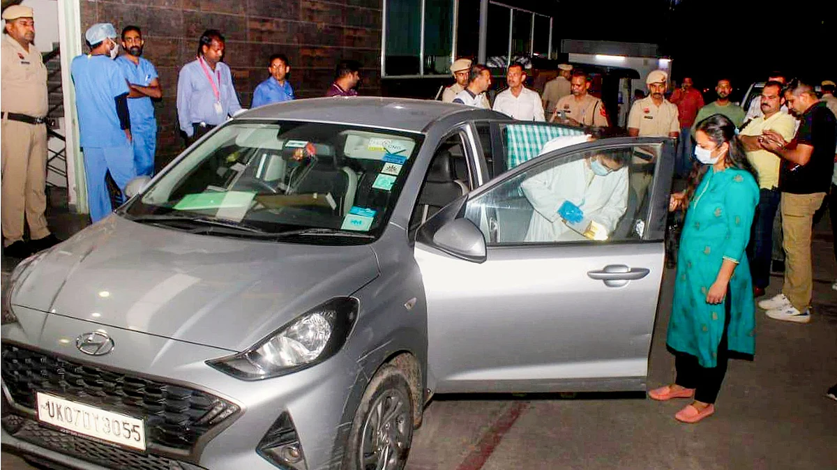 Police and forensic experts examine the car in which a family was found dead in Panchkula