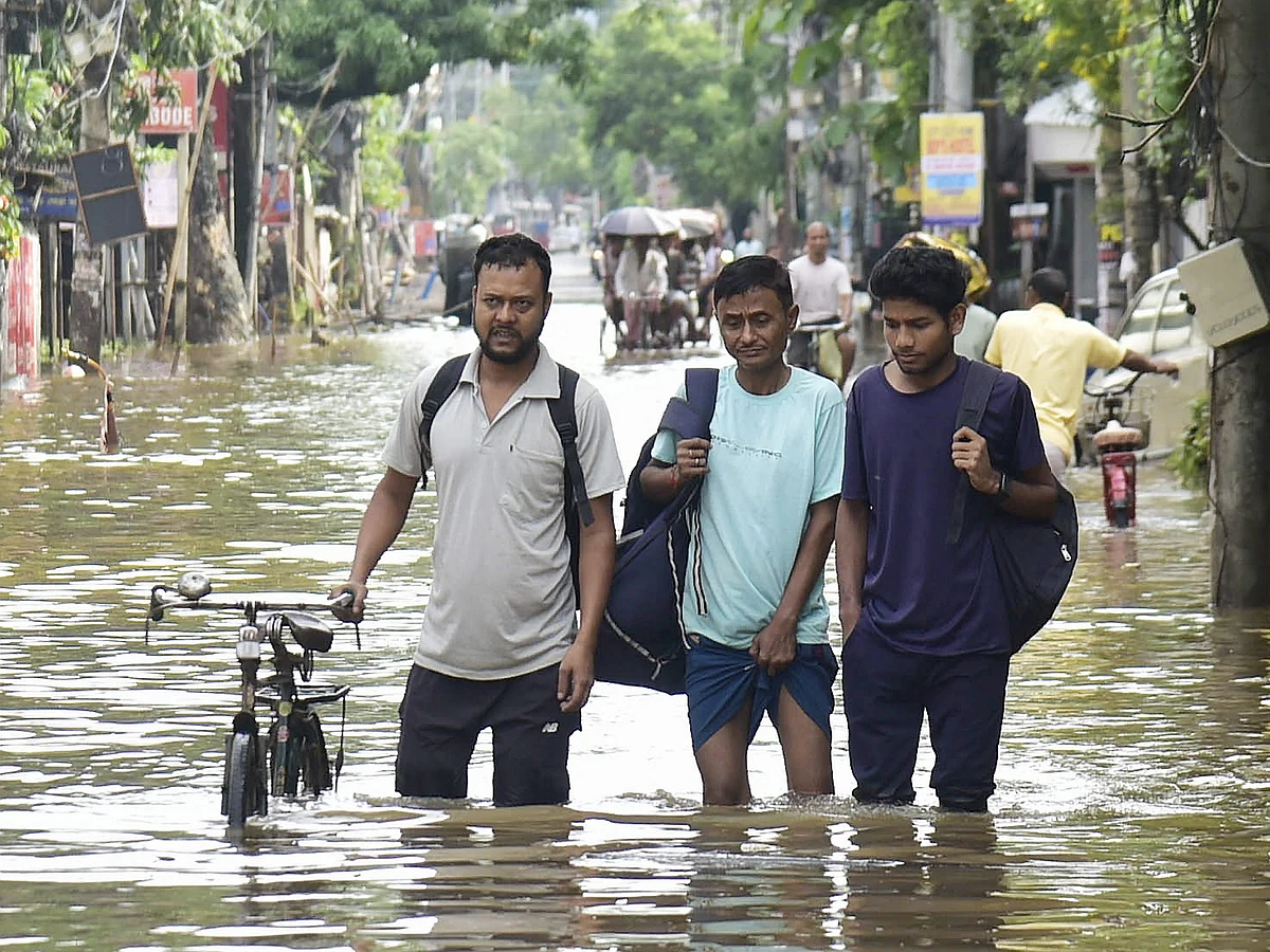 People wade through water in Assam on Saturday, 31 May