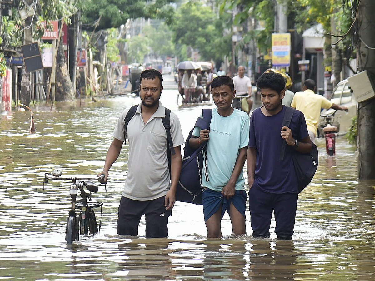 People wade through water in Assam on Saturday, 31 May