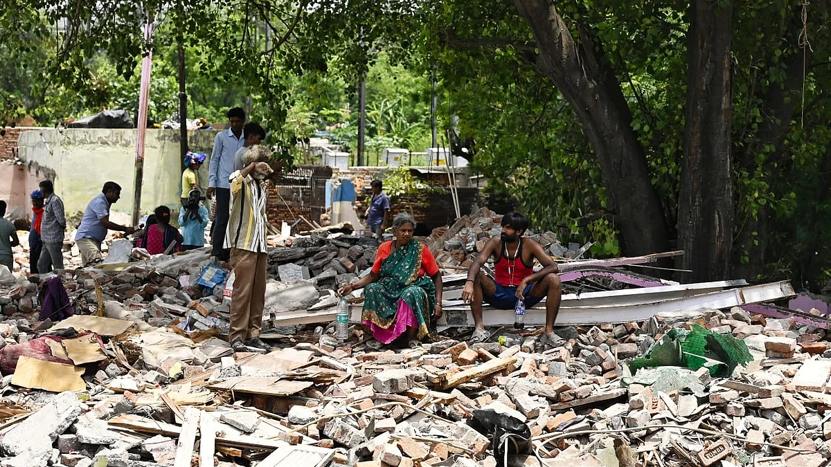 Residents sit amidst the rubble which was once their homes (photo: Vipin/NH)