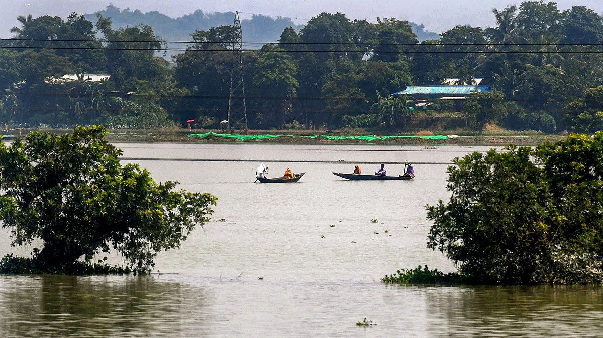 Villagers move through a flooded street in Morigaon on 8 June (photo: PTI)
