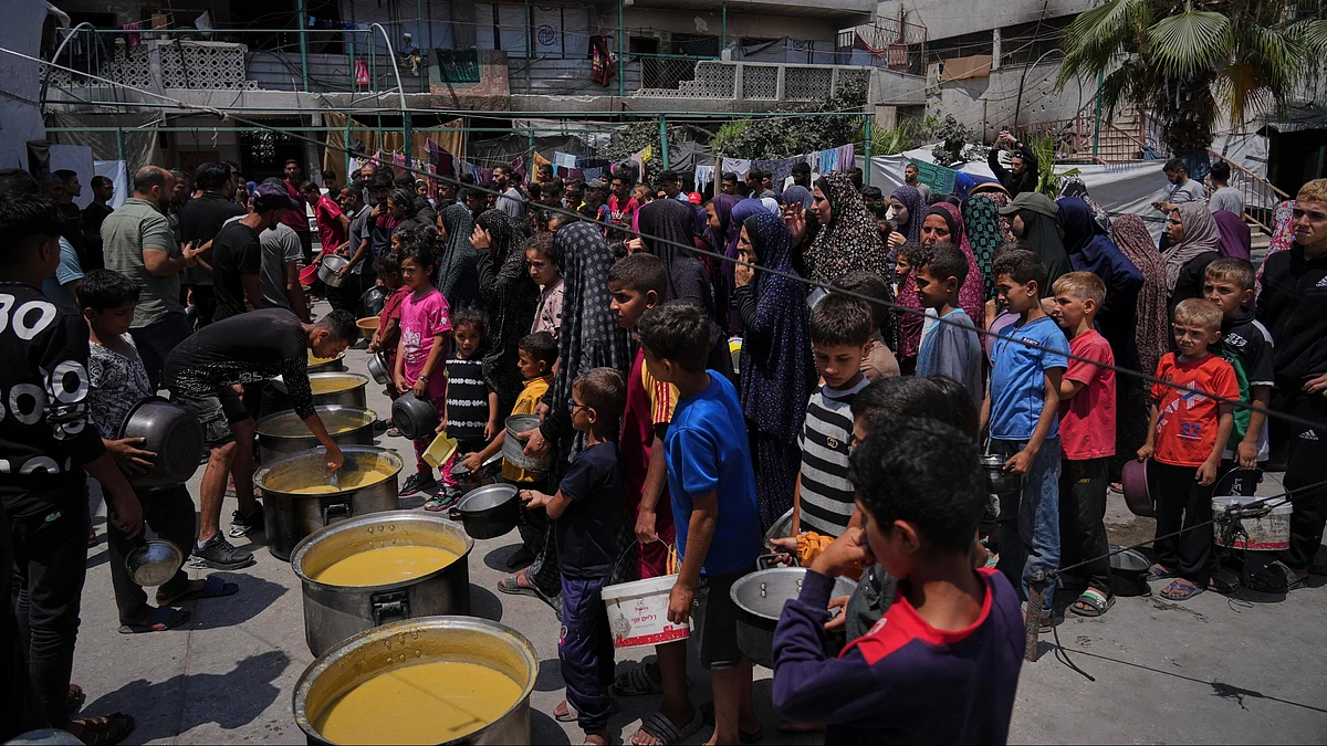Palestinians line up for food at community kitchen in Gaza City on 10 June (photo: AP/PTI)