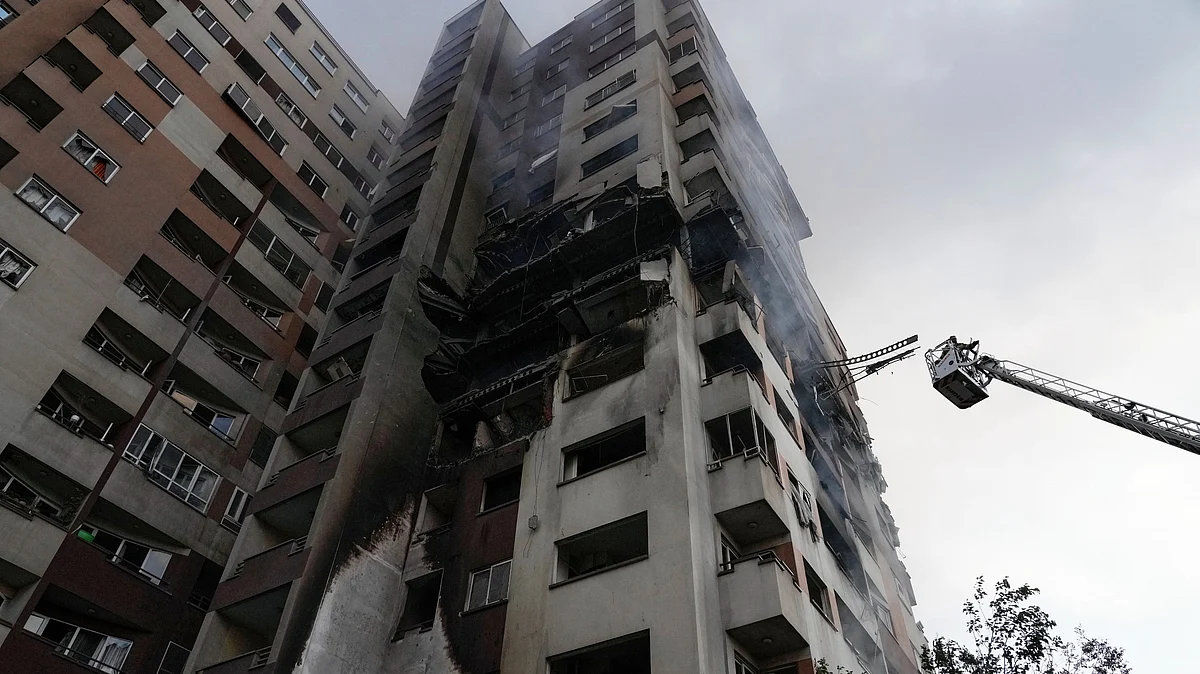 A firefighter on a crane at the scene of an explosion at a residential compound in Tehran (photo: AP/PTI)