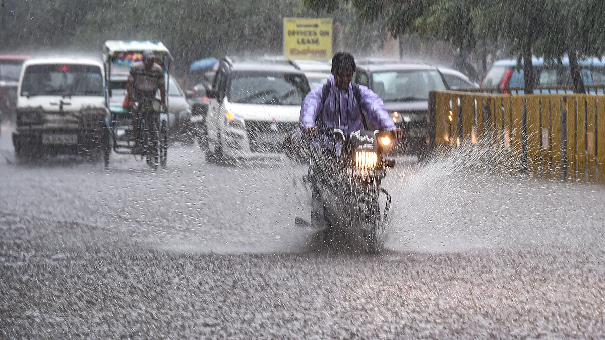 Vehicles move through a flooded street during heavy rainfall (photo: PTI)