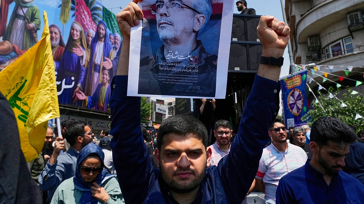A protester with a poster of the late Iranian chief of general staff of armed forces (photo: AP/PTI)