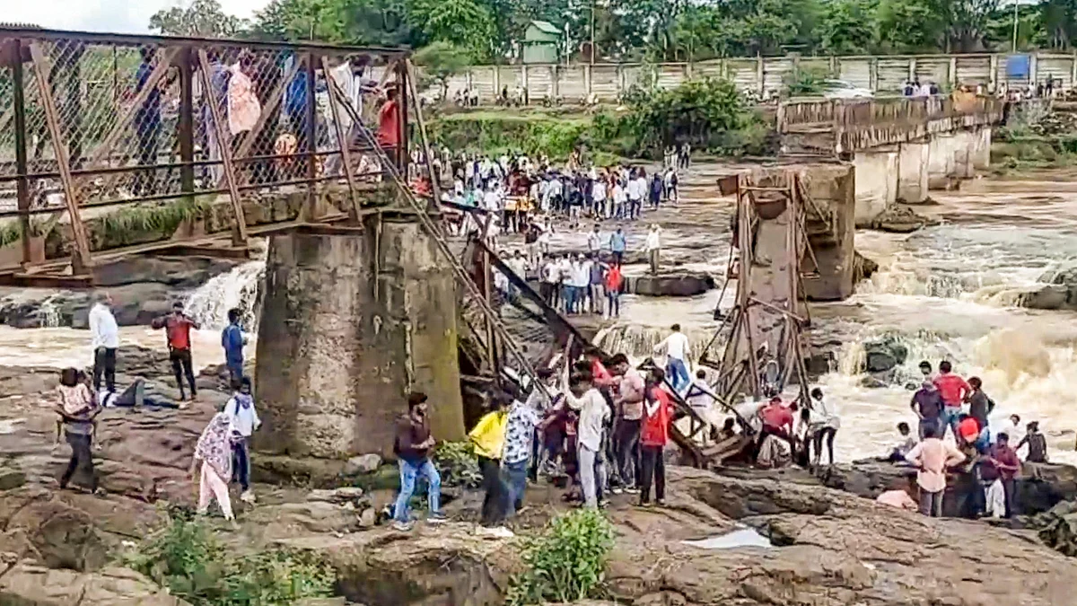 People stand near the collapsed iron bridge in Pune on 15 June (photo: PTI)