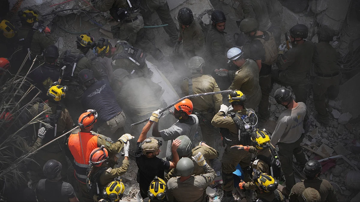 Israeli soldiers search for survivors in central Israel on 15 June (photo: AP/PTI)