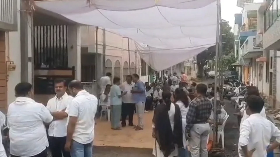 People gather outside former CM Vijay Rupani's residence in Ahmedabad on 16 June (photo: PTI)