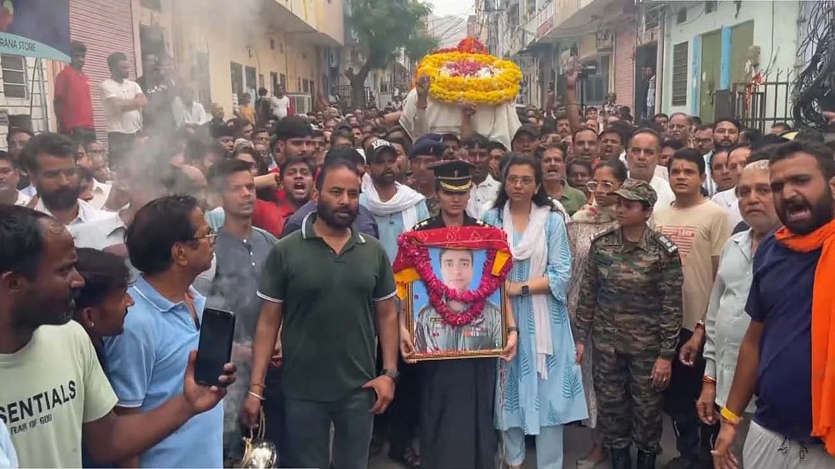 Lieutenant Colonel Deepika carries the portrait of Rajveer Singh Chauhan. (photo: PTI)