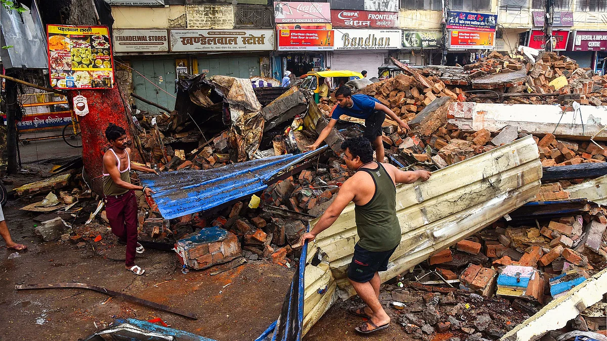Affected residents clear debris after demolition of shops on Lanka Road (photo: PTI) 