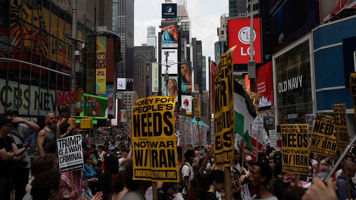 People hold signs during a protest against US strikes on Iran, in New York on 22 June (photo: AP/PTI)