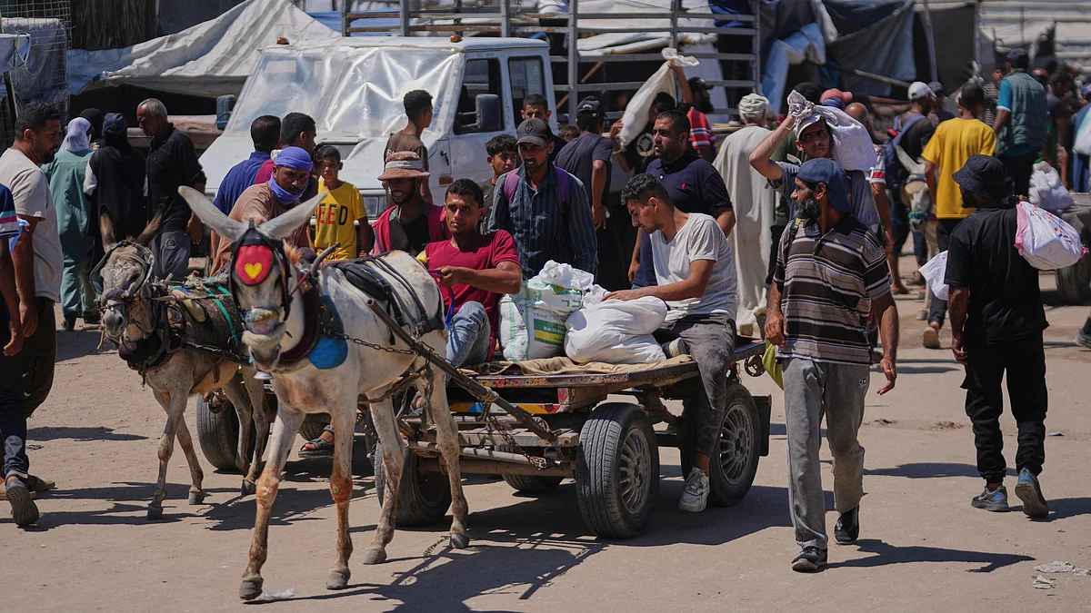 Palestinians carry food in Rafah on 25 June (photo: AP/PTI)