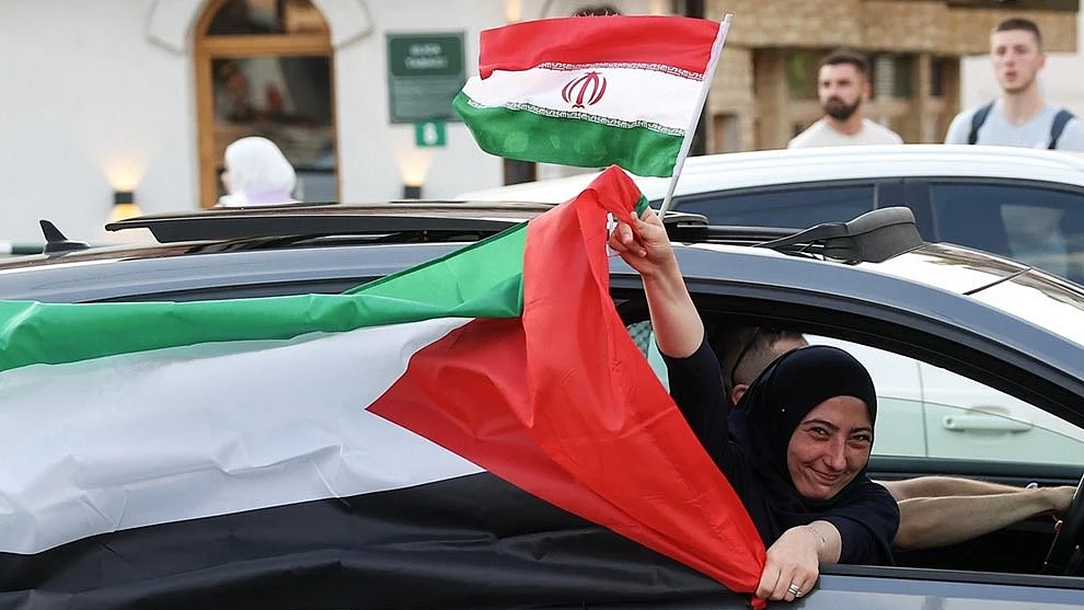 Bosnian Muslims celebrate, carrying the flags of Iran and Palestine, after the ceasefire