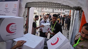 Palestinians receive food parcels in Gaza City on 26 June (photo: AP/PTI)