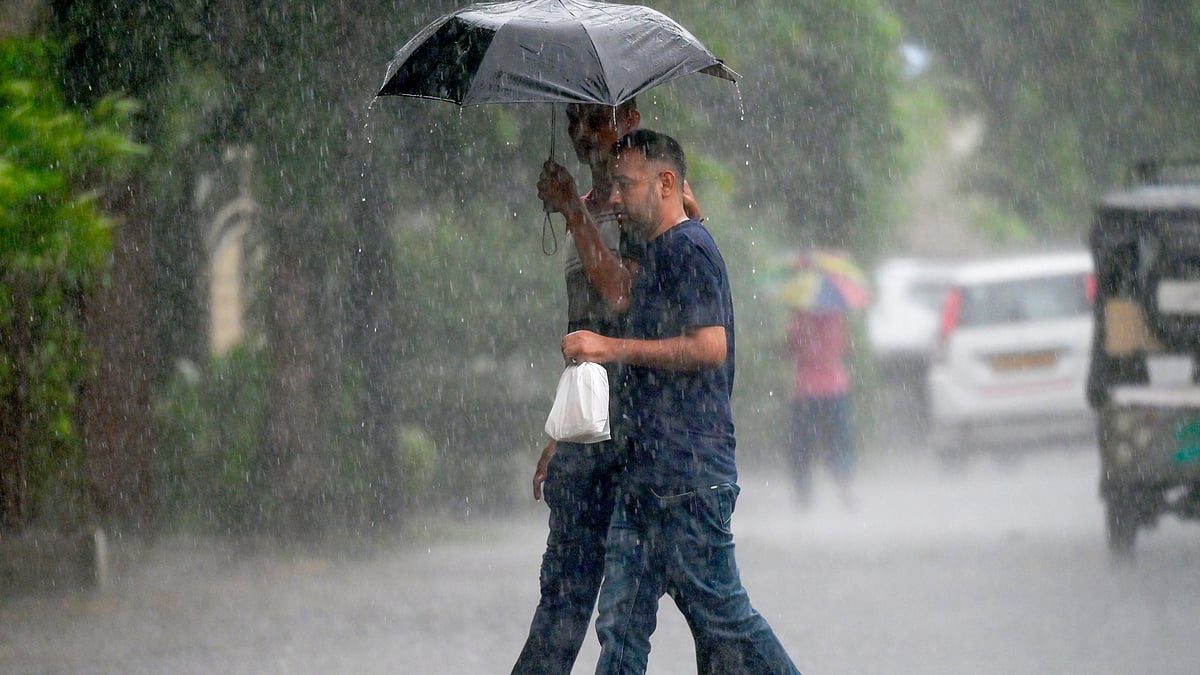 People try to protect themselves from rain in Noida on 13 July (photo: IANS)