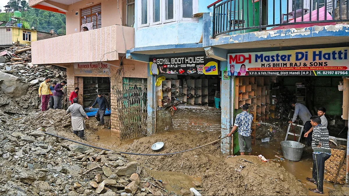 Shopkeepers remove debris after cloudbursts and landslides in Mandi district on 15 July (photo: PTI)