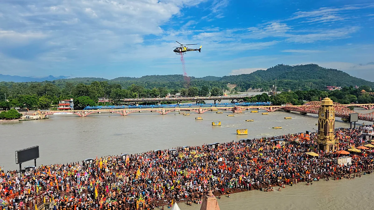 A helicopter showers flower petals on kanwariyas at Har Ki Pauri Ghat in Haridwar (photo: PTI)
