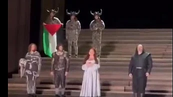 A performer holds the Palestinian flag at Opera House in London, 19 July 2025