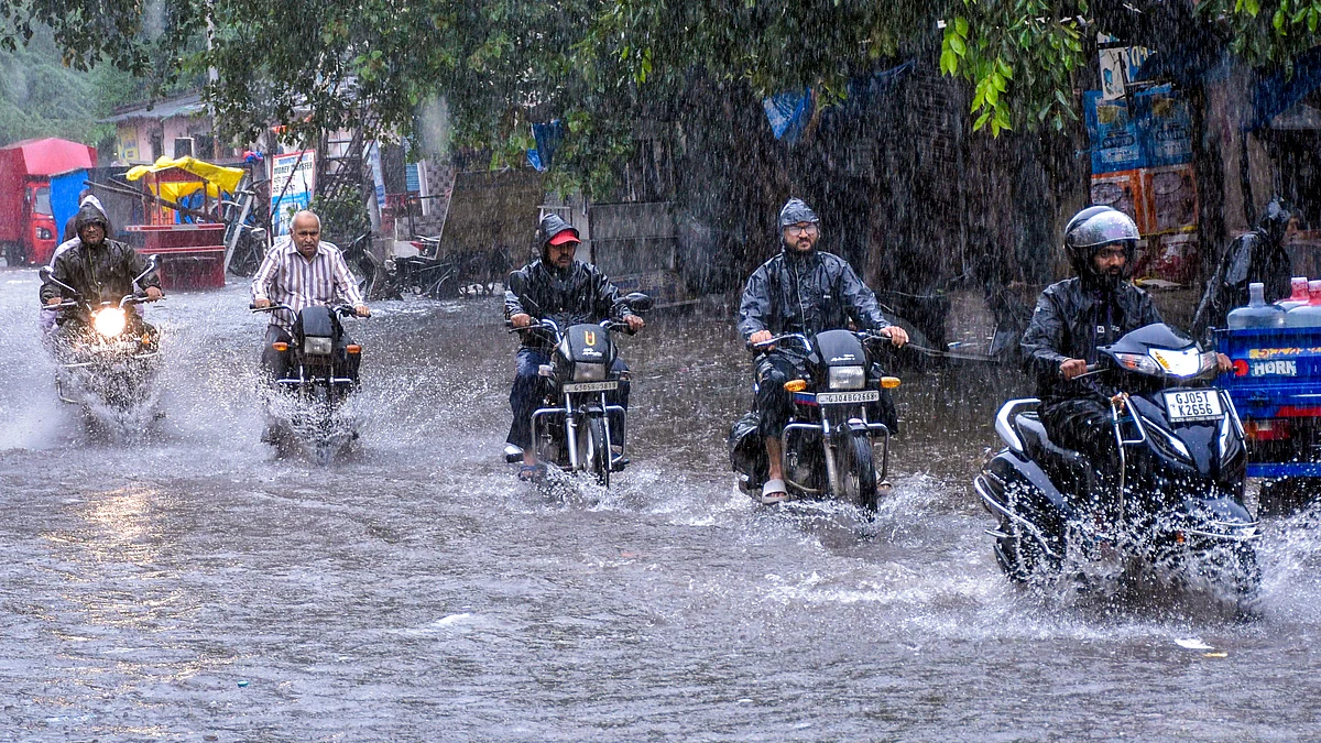 Commuters make their way through a waterlogged road in Surat (photo: PTI)