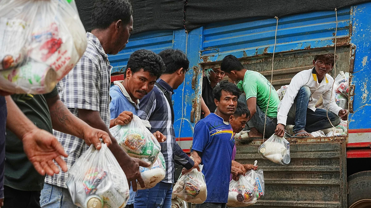 Local villagers help unloading supplies for refugees in Cambodia on 27 July (photo: AP/PTI)
