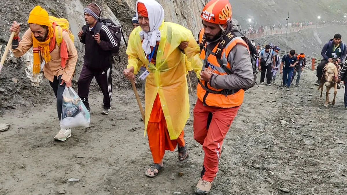 MRT member assists a pilgrim during the annual Amarnath Yatra in Anantnag district (photo: PTI)