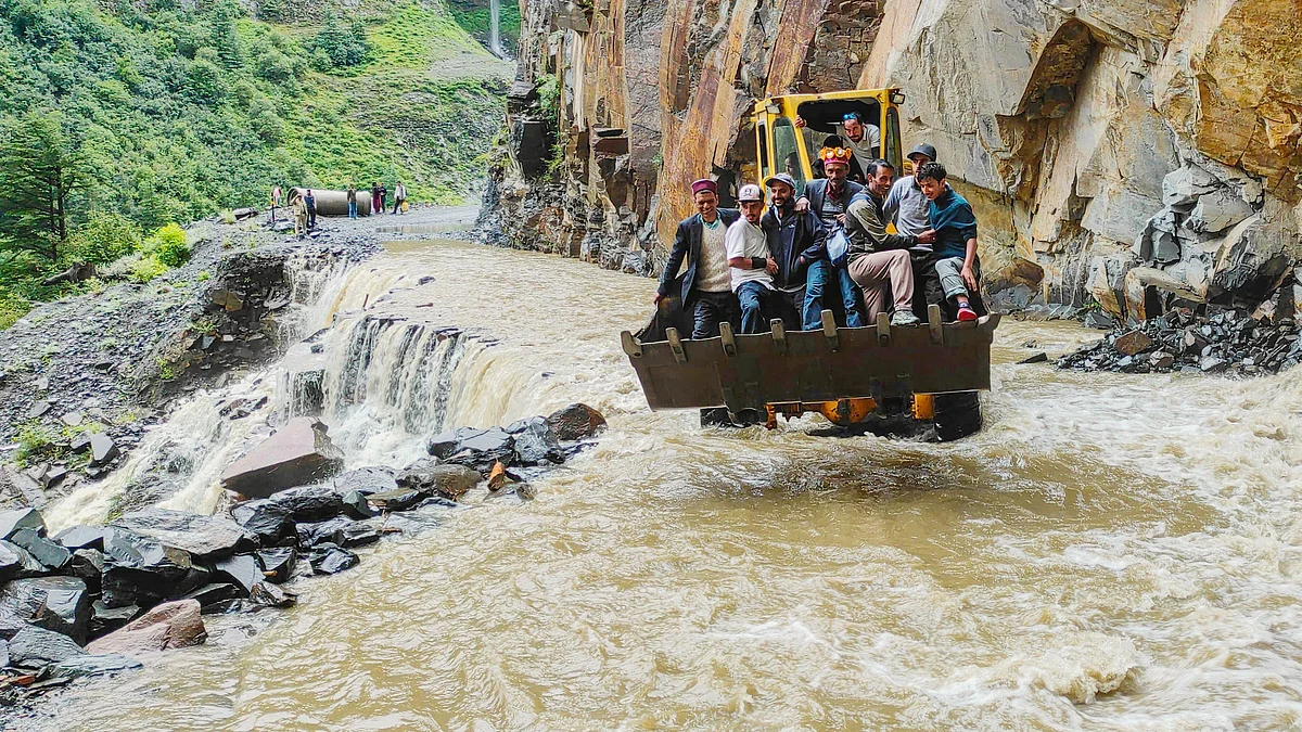 An excavator helps people cross a stream in Lahaul and Spiti (photo: PTI)