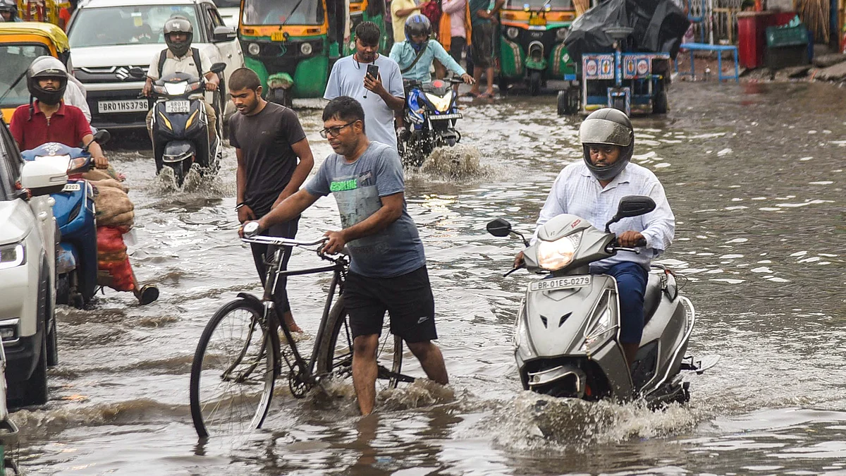 Commuters move through a waterlogged road in Patna on 3 August (photo: PTI)