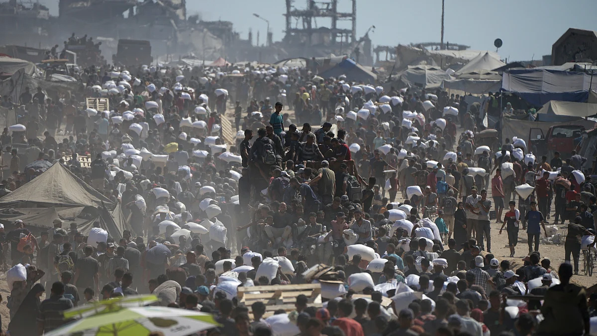 Palestinians carry sacks of flour taken from a humanitarian aid convoy in Gaza (photo: AP/PTI)