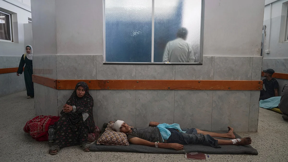 A shell of a hospital: An injured boy waits on the floor for treatment at Gaza's al Shifa Hospital