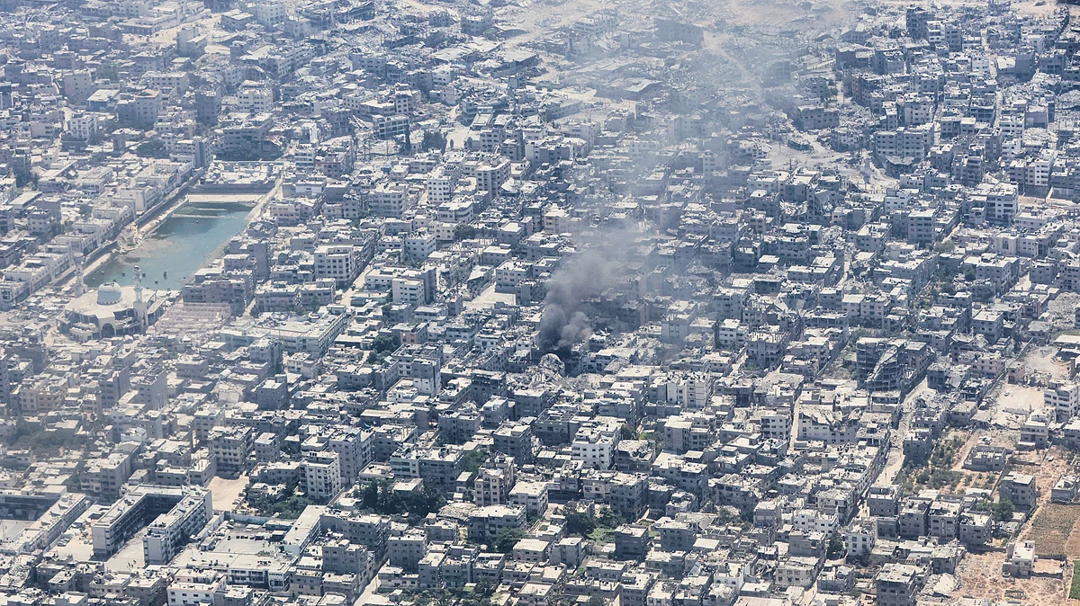 Smoke rises from Gaza City as seen from a Jordanian plane during an airdrop of humanitarian aid