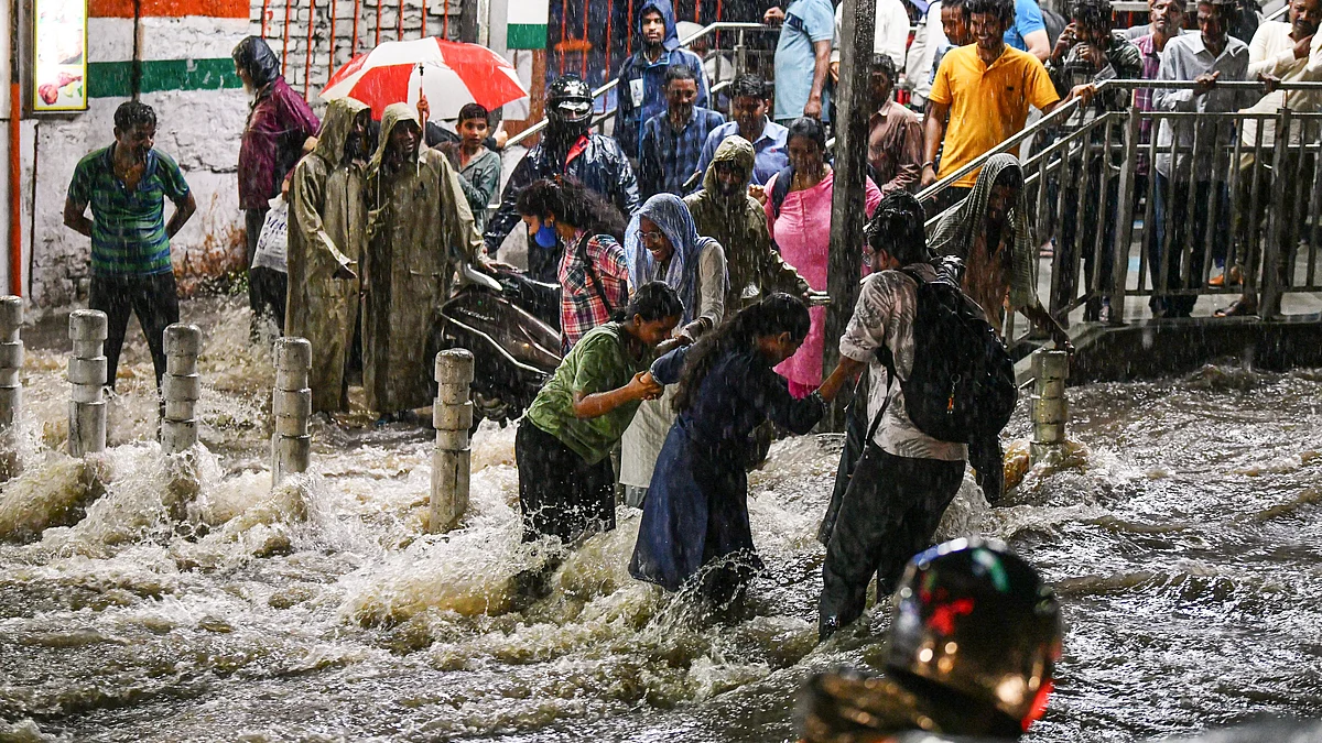 Commuters find their way through a waterlogged road in Hyderabad on 7 August 
